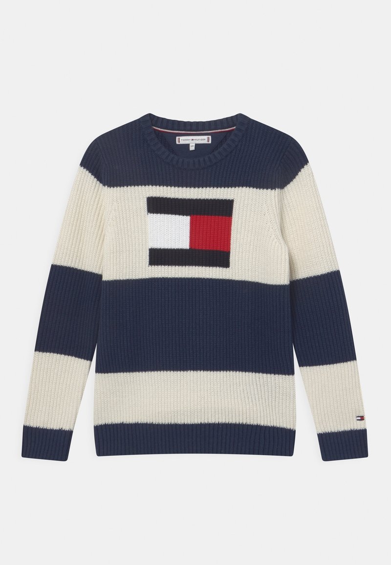 Pull en maille rayé bleu marine et crème avec col rond et logo rectangulaire rouge, blanc et noir sur la poitrine.