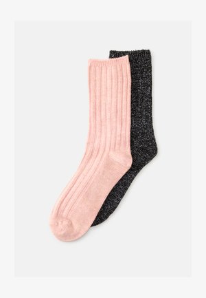 Zwei Paar knielange Socken: ein Paar ist weich rosa mit geripptem Textur, das andere ist schwarz mit metallischen Akzenten, beide haben eine glatte Oberfläche.