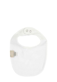 Vit bomullsmössa med rundad form, öppen hals och två tryckknappar. Har en tagg på sidan för varumärkesidentifikation. Mjuk och absorberande textur.