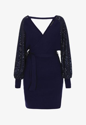Marineblå kjole med indpakningsdesign, ribbet tekstur og pufærmer dekoreret med perler. Har en bælte med bindebånd og V-hals, hvilket skaber en tætsiddende silhuet.