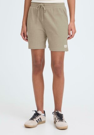 Helle khakifarbene kurze Hose aus geripptem Stoff mit elastischem Bund und Kordelzug; verfügt über ein kleines Markenlabel am Saum.