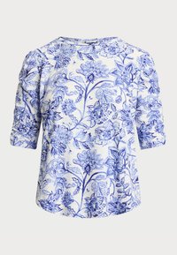 Blusa floreale con un motivo blu e bianco, realizzata in tessuto morbido. Ha un collo rotondo e maniche a tre quarti.