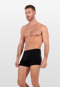 Černé boxerky s širokým elastickým pasem s embosovaným logem, vyrobené z měkké a elastické tkaniny pro pohodlí a správné padnutí.