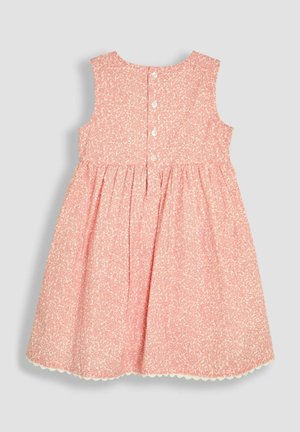 Růžové šaty s květinovým vzorem, bez rukávů, s nařasenou sukní a vroubkovaným lemem. Má zapínání na knoflíky na zadní straně.