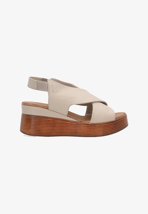 Beige Leder-Wedge-Sandale mit Kreuzdesign, offenem Zeh, elastischem Fersenriemen und einer strukturierten Holz-Plattformsohle.