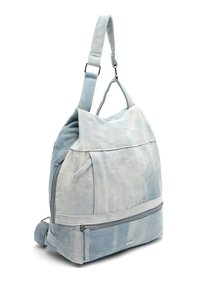 Ljust blå denimryggsäck med en slouchy form, utrustad med ett dragkedjeförsett framsPocket och justerbara remmar för mångsidighet. Mjuk textur och subtila graderingar.