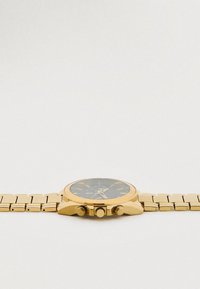 Goldene Uhr aus Edelstahl mit schwarzem Zifferblatt, Chronographen-Unterzifferblättern und strukturiertem Armband. Verfügt über drei Drücker und eine strukturierte Lünette.