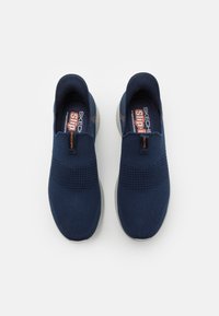 Sneakers slip-on blu navy con tomaia in maglia testurizzata e banda elastica superiore; presentano una suola in gomma per la trazione.