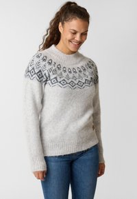 Light gray knitted sweater with a round neckline, featuring a dark geometric pattern at the yoke and ribbed cuffs and hem.