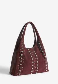 Burgundska suede torba s metalnim nijansama i dvostrukim ručkama, koja ima ležeran oblik i dekorativne ukrasne linije s metalnim nitnama.