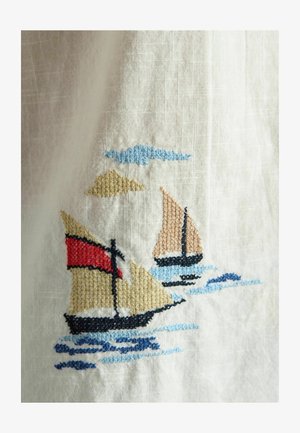 Two sailboats with beige and red sails embroidered on white fabric, with blue waves and a blue cloud above.