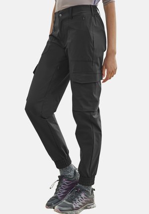 Schwarze Cargo-Hose mit elastischen Bündchen, mehreren Taschen und glatter Textur, kombiniert mit dunklen Sportschuhen und grauen Socken.