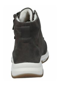 Bottines chelsea en cuir noir foncé avec semelle blanche, dotées d'une fermeture éclair à l'arrière, d'une doublure en peluche et de détails de couture contrastés.