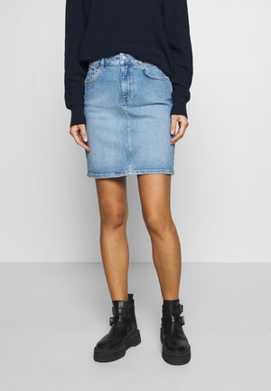 Lys blå denimnederdel i mid længde med en tætsiddende pasform, med for- og baglommer samt en glat tekstur. Sammen med sorte ankelstøvler.