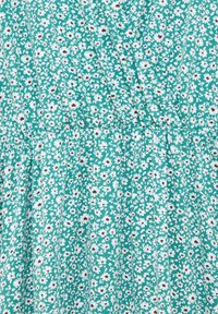 Tissu bleu canard avec un motif floral blanc, présentant de petites marguerites avec des centres marron. Design froncé avec des plis verticaux. Texture douce.