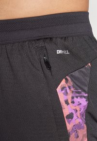 Black athletic shorts featuring a textured fabric, mesh waistband, and side panel with a pink and purple abstract pattern.