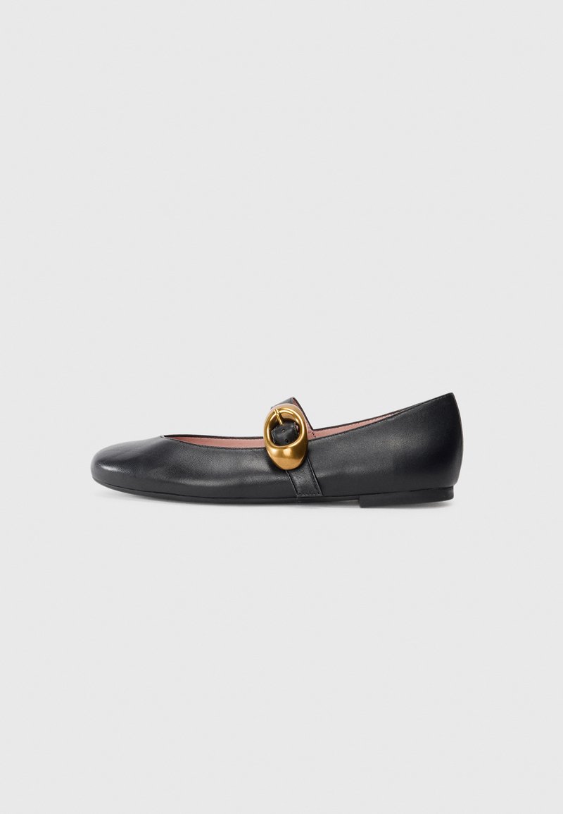 Ballerine en cuir noir avec un bout rond, ornée d'un accent circulaire doré sur une sangle. Texture lisse ; semelle plate et basse.