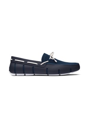 Marineblauwe slip-on bootschoen met witte touwveters en witte gesegmenteerde rubberen zool, ontworpen voor casual gebruik.