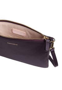 Borsa in pelle viola con una texture granulosa, chiusura con zip e un accento in metallo color oro. Interno foderato in tessuto chiaro con etichetta del marchio.