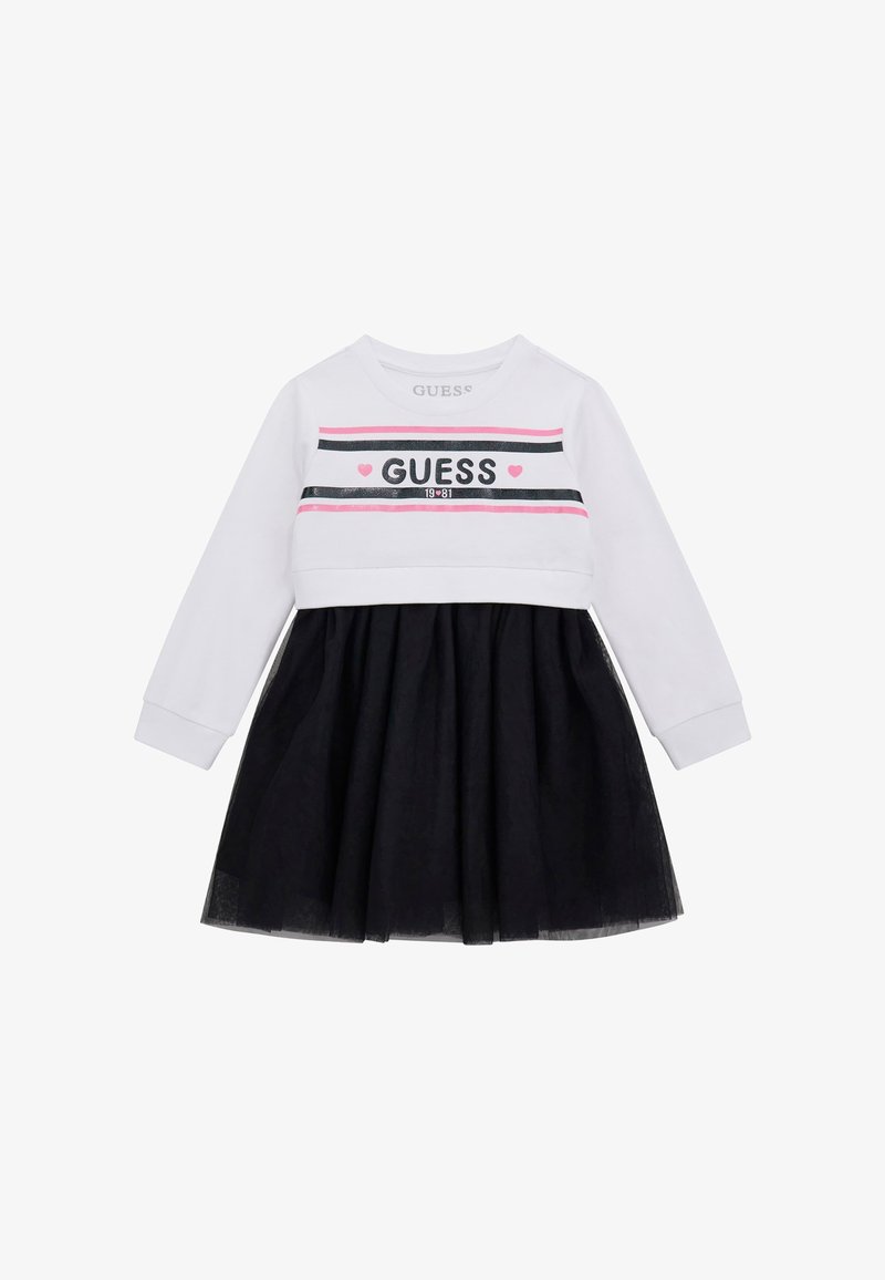 Abito a maniche lunghe con parte superiore bianca a righe nere e rosa e scritta "GUESS", abbinato a una gonna in tulle nera.