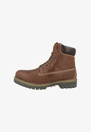 Brauner Leder-Stiefelette mit abgerundetem Zehenbereich, gepolstertem Kragen, weißen Nähten und einer Gummisohle mit Profilmuster.