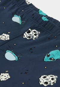 Kraťasy pro chlapce v námořnické modré barvě s grafikou mimozemšťanů a vesmírných lodí, s elastickým pasem a hladkým, jemným textura.