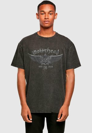 Black oversized T-shirt made of cotton, featuring a faded graphic print of "Motörhead" with wings and skull design on the front.