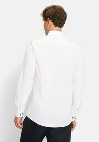 Weißes Langarmhemd mit klassischem Kragen. Verfügt über Knopfmanschetten und eine taillierte Passform, hergestellt aus glattem Stoff mit einem leicht glänzenden Finish.