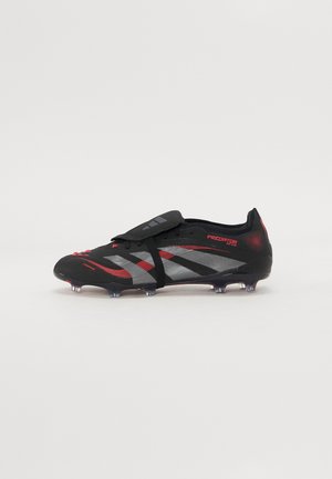 Black and red soccer cleat with a sleek design, featuring a textured upper, strap closure, and a multi-stud sole for traction.