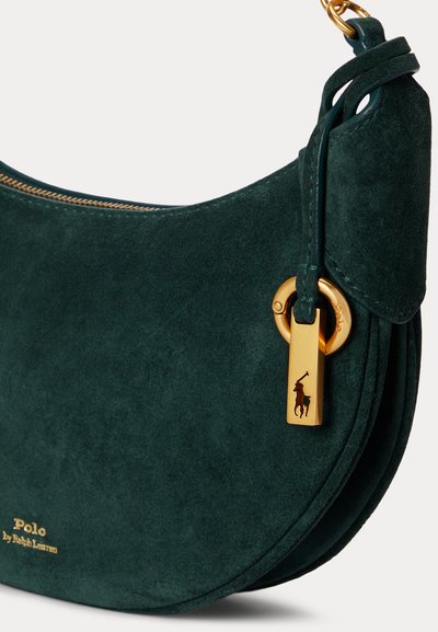 Τσάντα Polo από σκούρο πράσινο σουέντ Ralph Lauren με χρυστό φερμουάρ και μια χρυσή ταμπελίτσα με το λογότυπο του αλόγου της μάρκας κρεμασμένη από το λουρί.