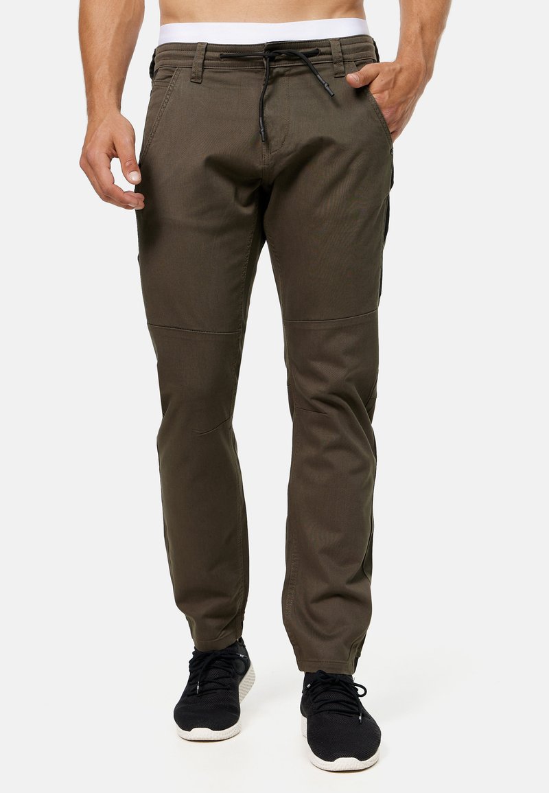 Donkergroene broek van textuurstof, met een trekkoord in de taille, taps toelopende benen en zijzakken.
