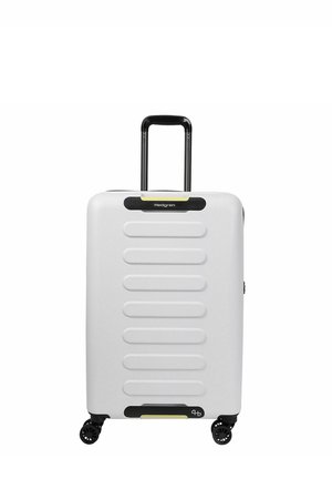 Valise rigide blanche avec poignée rétractable noire et quatre roues pivotantes noires, présentant des nervures horizontales en relief à l’avant.
