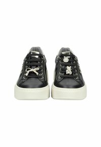 Des baskets en cuir noir présentent des accents décoratifs, y compris des gemmes et un nœud, avec une semelle plateforme blanche et des lacets noirs.