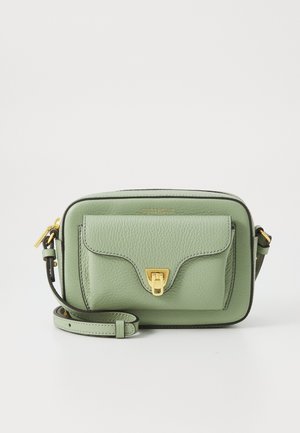 Green leather crossbody bag with a textured finish, gold hardware, front flap pocket, and an adjustable strap. Compact rectangular shape.