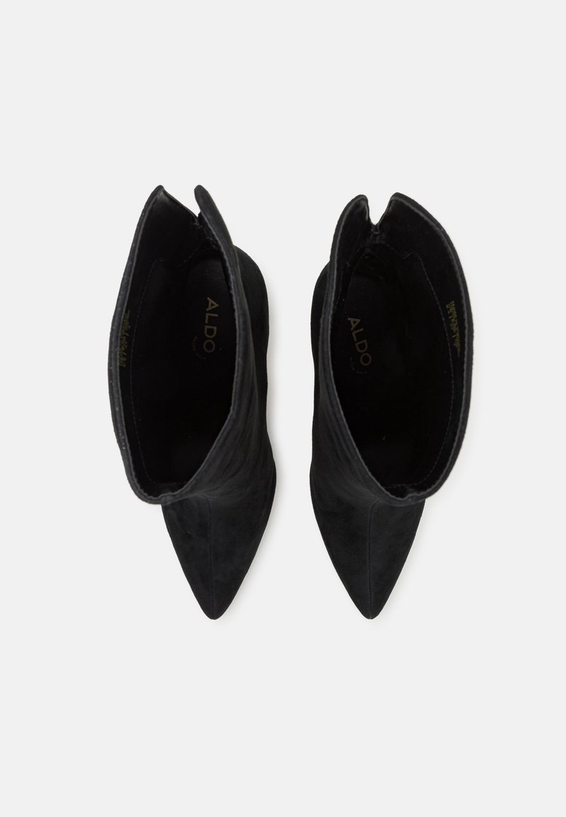 Stivaletti in suede neri con punta affusolata, caratterizzati da un design elegante e senza accessori visibili. La parte superiore ha una texture liscia con dettagli ritagliati.