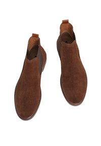 Botines de ante marrón con paneles laterales elásticos, punteras redondeadas y lengüetas. Los detalles de la suela incluyen costuras sutiles y un acabado texturizado.
