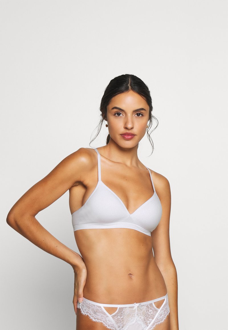 Lichtgrijze bralette met dunne bandjes en een V-vormige halslijn. Zachte textuur met minimale versieringen. Gecombineerd met kanten slipjes.