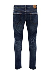 Jeans din denim albastru închis, cu un croi slim, având buzunare la spate, o etichetă de marcă bej la talie și decolorare ușoară pe coapse.