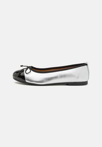 Balleti tossud metallilise hõbedase nahkdetailiga ja läikiva musta lakkninaga, mille esiosas on paeltega aktsent. Lame talla.