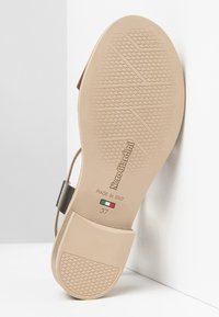 Suola di scarpa color beige chiaro con motivo testurizzato, con il marchio "NeroGiardini". Include una fascia nera e la marcatura della taglia 37. Prodotto in Italia.