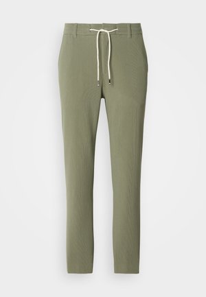 Green ribbed pants with a drawstring waist, featuring a smooth texture and tapered legs. Subtle silver detailing on the drawstring tips.