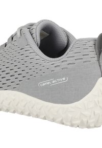 Graue Mesh-Sneaker mit strukturiertem Design, weißer Gummisohle mit Zickzackmuster und einem Logo an der Seite.