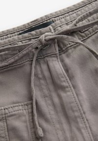Grijze katoenen shorts met een trekkoordsluiting, gestikte zakken en een gladde, lichtgetextureerde stof.