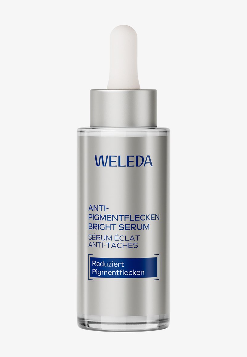 Weleda Serum Rozjaśniające Anty-Pigmentowe w przezroczystej, srebrnej szklanej buteleczce z kroplomierzem. Niebieski tekst na etykiecie podkreśla szczegóły produktu.