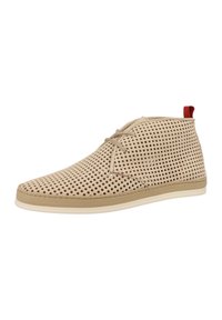 Sneakers perforati beige con profilo basso, design con lacci e un piccolo accento rosso sul tallone. Presentano una texture liscia e suola in gomma.