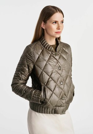 Pikowana oliwkowa kurtka wykonana z błyszczącego materiału, z stójką, zatrzaskami i ściągaczami przy mankietach. Posiada boczne kieszenie.