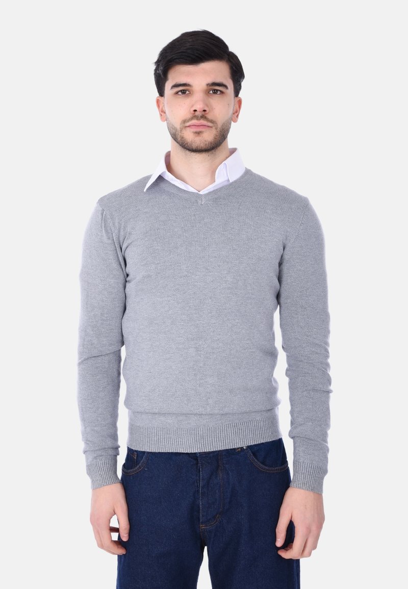 Maglione grigio lavorato a maglia con scollatura a V, orlo e polsini a coste, indossato sopra una camicia bianca con colletto. Presenta una texture liscia e un design aderente.