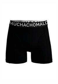 Črne boksarice z mehko teksturo, ki imajo bel elastičen pas s tekstom "MUCHACHO MAL" v debelih črkah.