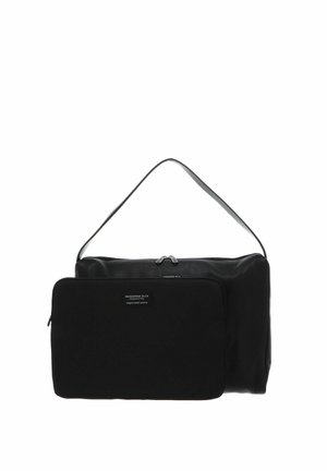 Sac à bandoulière en cuir noir avec une poche zippée noire à l'avant, comportant une étiquette avec un texte blanc.