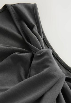 Grått tygtop med en tvinnad frontdesign, mjuk textur och släta kanter med minimala sömnadsdetaljer.